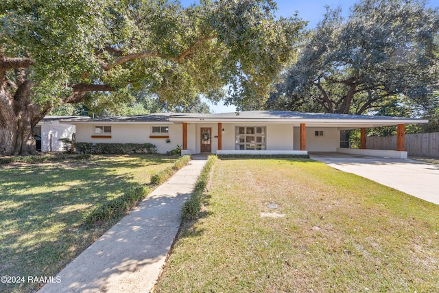 ranch-style home featuring a carport, a porch, and a front yard