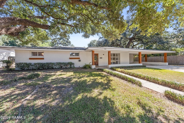 single story home with a carport, covered porch, and a front yard