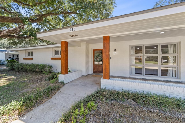 view of exterior entry featuring covered porch