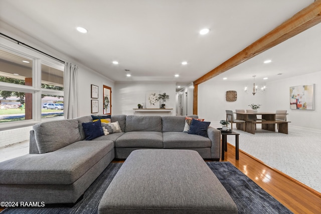 living room with beam ceiling, dark hardwood / wood-style floors, and an inviting chandelier