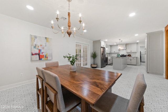 dining space with crown molding, french doors, and an inviting chandelier