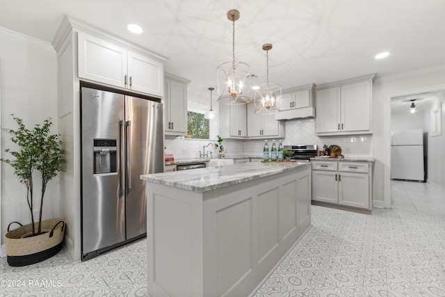 kitchen featuring a center island, hanging light fixtures, stainless steel appliances, light stone counters, and crown molding