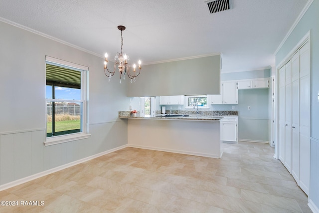 kitchen featuring hanging light fixtures, white cabinets, kitchen peninsula, a textured ceiling, and ornamental molding