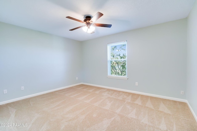 spare room with light carpet and ceiling fan