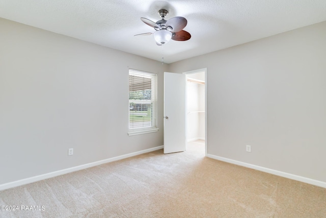 carpeted spare room with ceiling fan and a textured ceiling