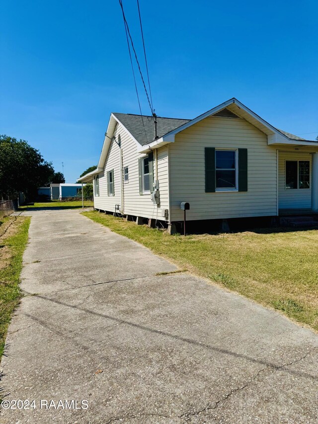 205 Gauraud St, Abbeville, LA 70510 - view of side of home with concrete driveway and a yard