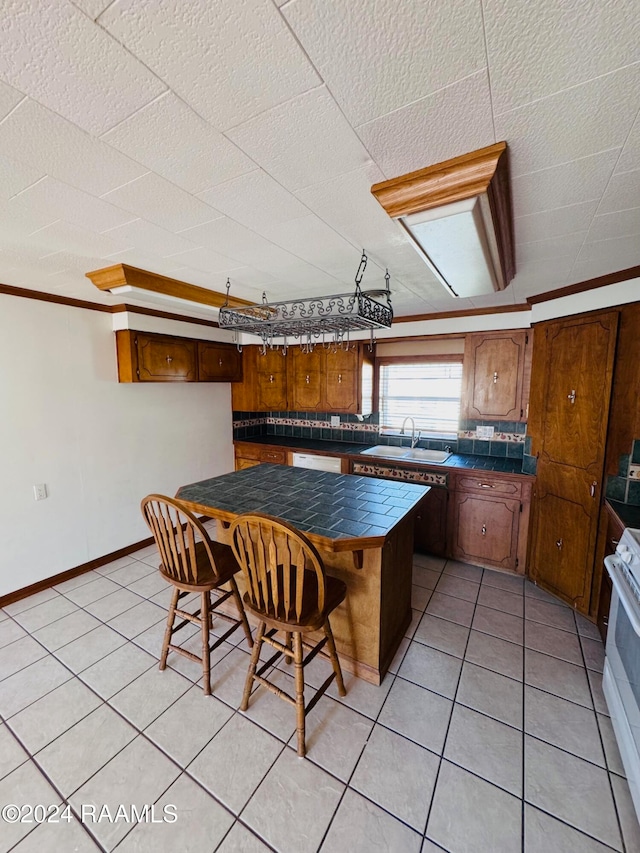 kitchen with white appliances, sink, ornamental molding, decorative backsplash, and light tile patterned floors