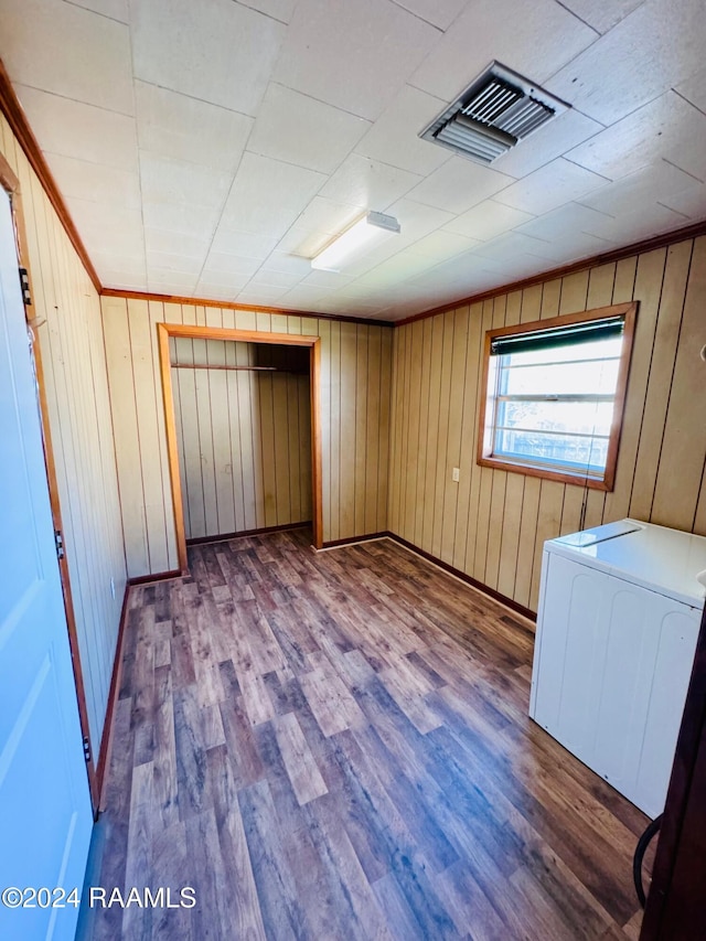 205 Gauraud St, Abbeville, LA 70510 - empty room featuring wood finished floors, wood walls, washer / clothes dryer, and baseboards