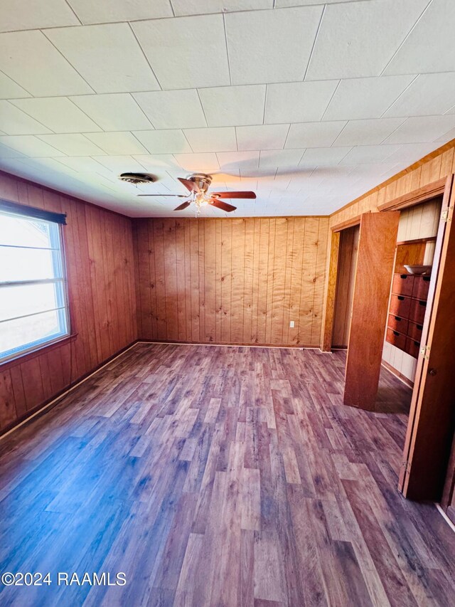 205 Gauraud St, Abbeville, LA 70510 - spare room with wood walls, dark wood-type flooring, and ceiling fan