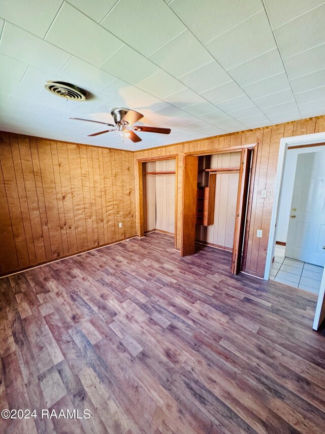 205 Gauraud St, Abbeville, LA 70510 - spare room with wooden walls, wood finished floors, and ceiling fan