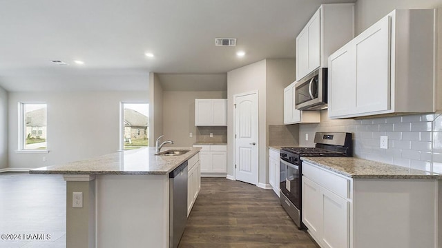 kitchen featuring white cabinets, dark hardwood / wood-style floors, a kitchen island with sink, and appliances with stainless steel finishes