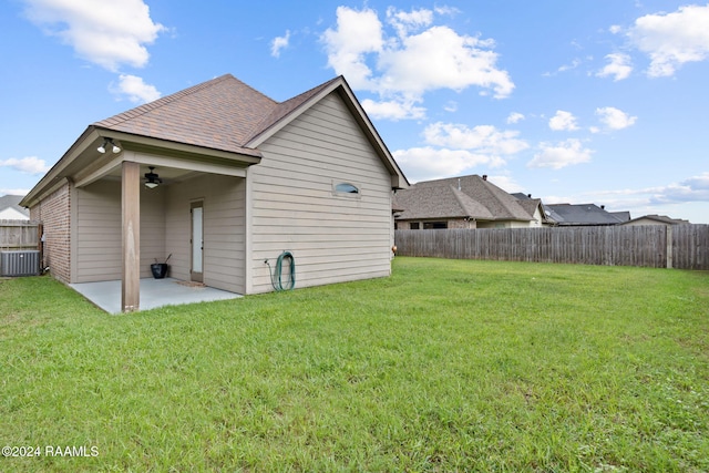 rear view of property with a patio area, a yard, and cooling unit