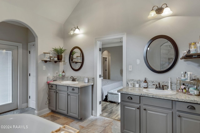 bathroom featuring vanity, lofted ceiling, and hardwood / wood-style floors