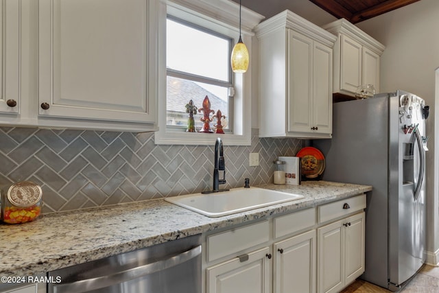 kitchen with stainless steel appliances, sink, tasteful backsplash, light stone countertops, and pendant lighting