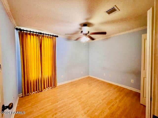 spare room featuring ceiling fan, a textured ceiling, hardwood / wood-style floors, and ornamental molding