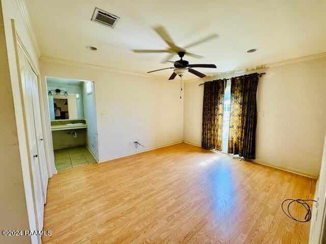 empty room featuring ceiling fan, ornamental molding, and light hardwood / wood-style floors