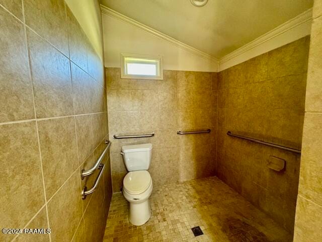 bathroom with lofted ceiling, tile walls, tile patterned floors, ornamental molding, and toilet