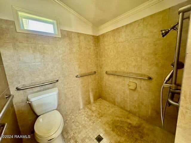 bathroom featuring tile walls, vaulted ceiling, tiled shower, and toilet