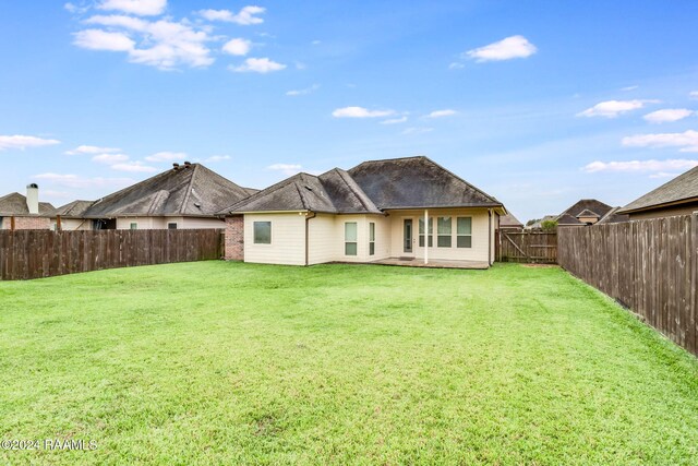 rear view of house featuring a lawn