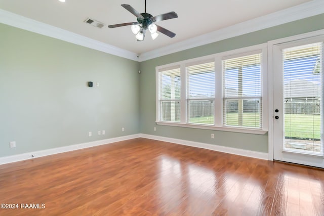 unfurnished room with plenty of natural light, ornamental molding, and hardwood / wood-style flooring