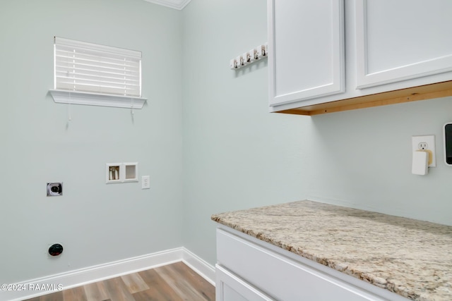 clothes washing area featuring hookup for an electric dryer, washer hookup, light wood-type flooring, cabinets, and ornamental molding