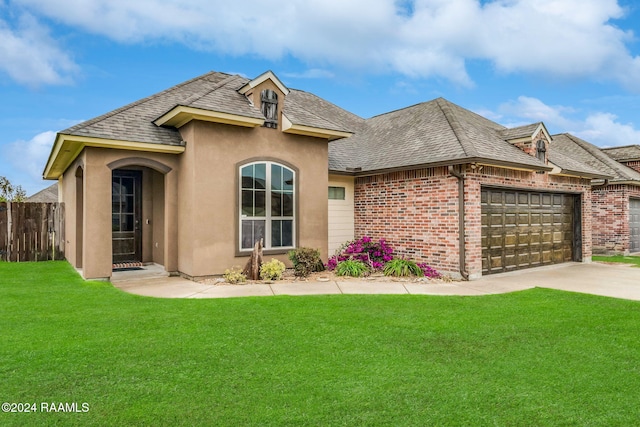 french country inspired facade featuring a front yard and a garage