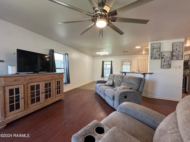 living room featuring ceiling fan and dark hardwood / wood-style floors