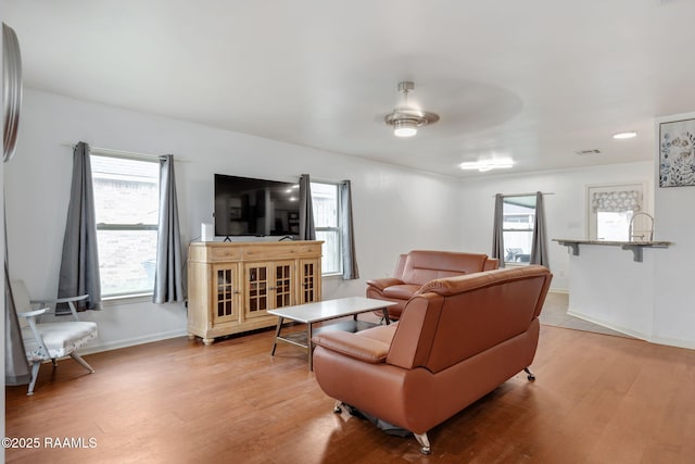 living room with light hardwood / wood-style flooring and ceiling fan