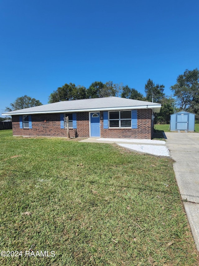 ranch-style house with a storage shed and a front yard