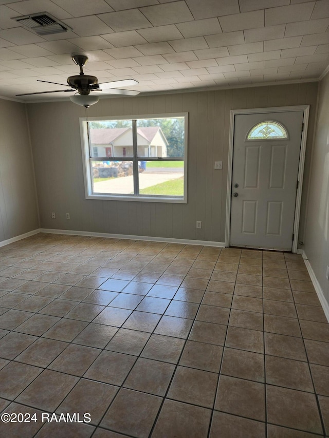 entrance foyer featuring ceiling fan, light tile patterned flooring, and crown molding