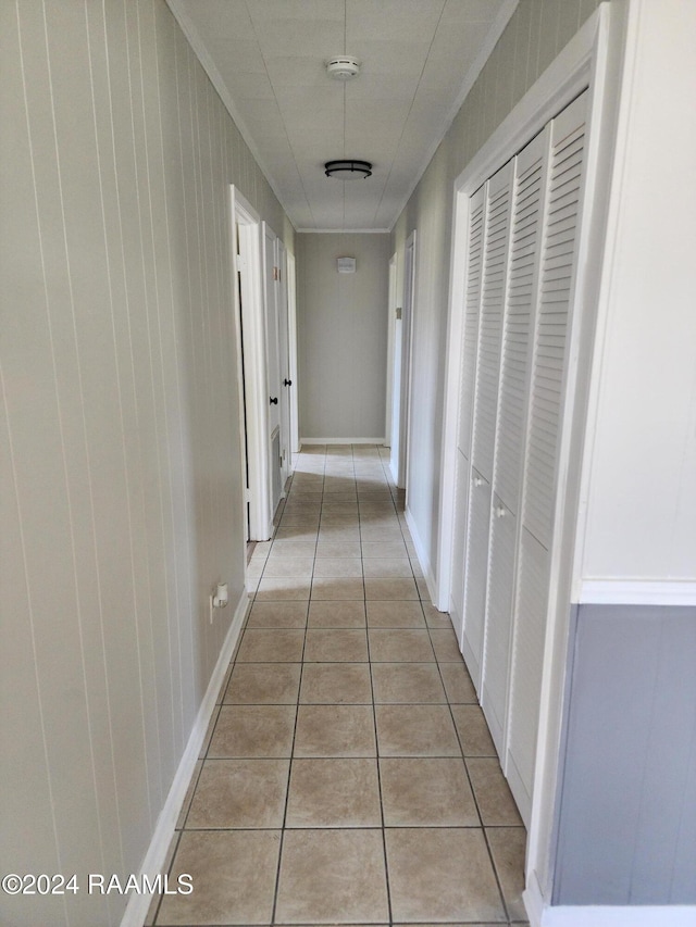 corridor featuring wood walls and light tile patterned floors