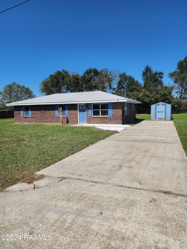 single story home featuring a shed and a front yard