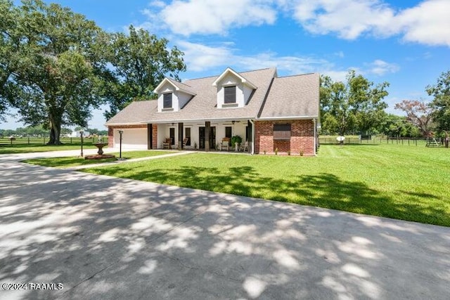 cape cod house with a front yard and a garage