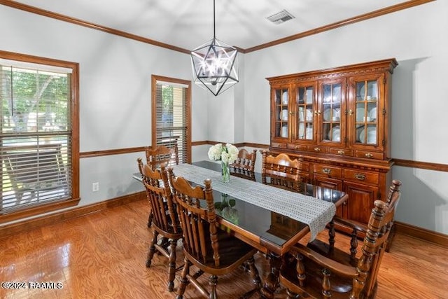 dining area featuring ornamental molding, a chandelier, and light hardwood / wood-style floors