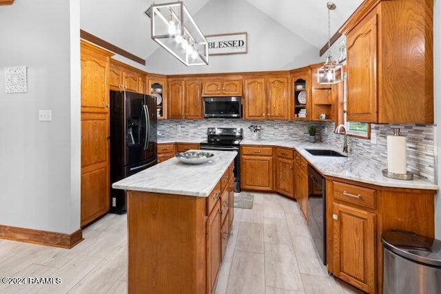 kitchen featuring pendant lighting, sink, backsplash, black appliances, and a center island