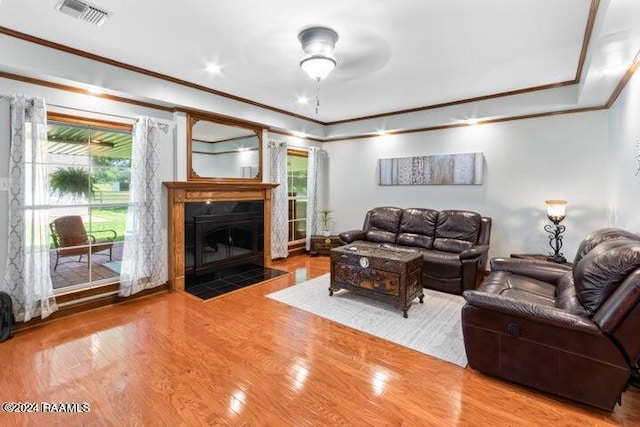 living room featuring plenty of natural light, crown molding, and hardwood / wood-style flooring