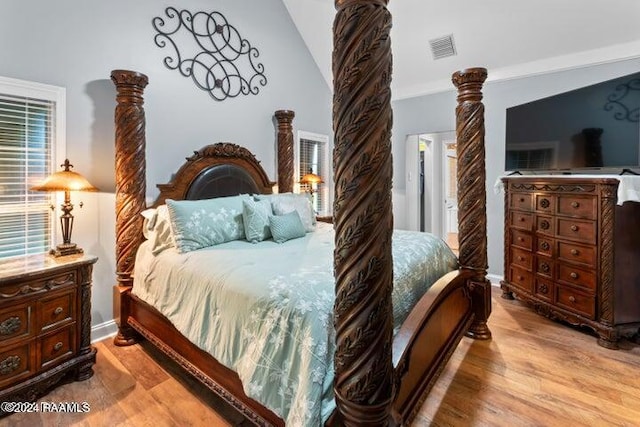 bedroom with ornamental molding, light hardwood / wood-style flooring, and vaulted ceiling