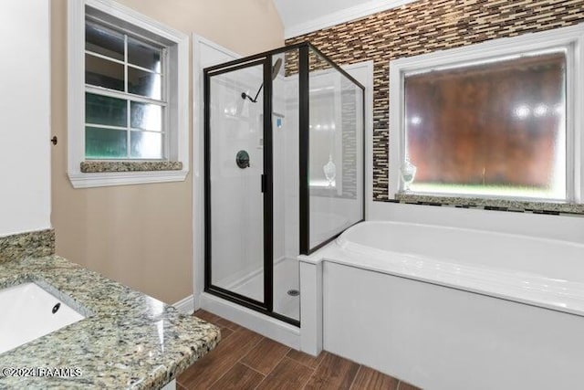 bathroom with separate shower and tub, hardwood / wood-style flooring, and vanity