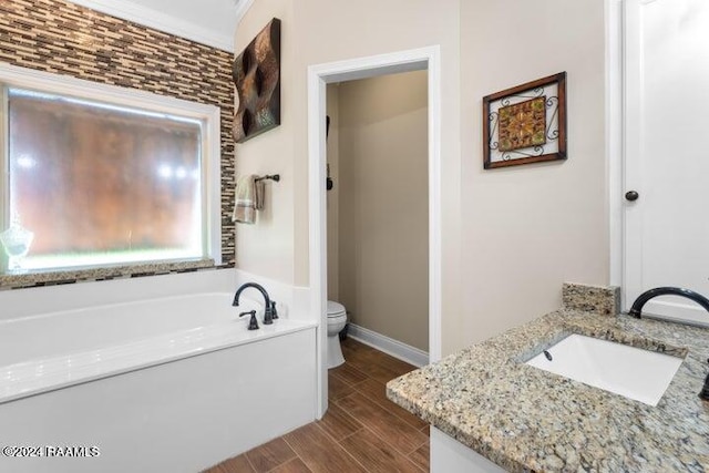 bathroom featuring vanity, a bathtub, toilet, crown molding, and hardwood / wood-style floors