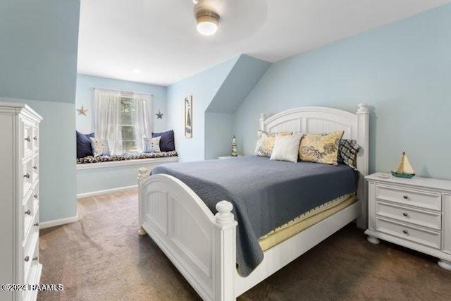 bedroom with ceiling fan, lofted ceiling, and dark colored carpet