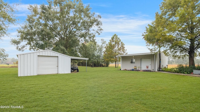 view of yard featuring a garage, an outdoor structure, and a carport