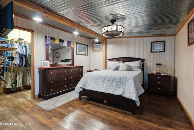 bedroom with ornamental molding, hardwood / wood-style floors, a walk in closet, a closet, and an AC wall unit