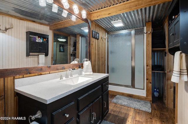 bathroom featuring vanity, beam ceiling, wood walls, an enclosed shower, and hardwood / wood-style flooring