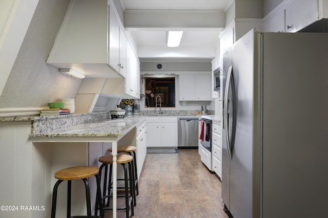 kitchen featuring stainless steel appliances, hardwood / wood-style flooring, kitchen peninsula, a kitchen breakfast bar, and white cabinets