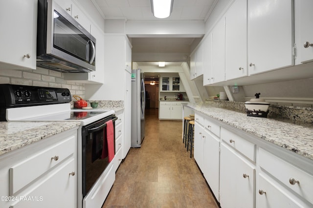 135 Woodys Ln, Sunset, LA 70584 - kitchen with stainless steel appliances, white cabinets, backsplash, light wood-style flooring, and light stone countertops