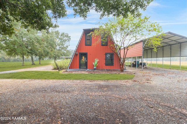 view of side of property featuring a carport and a yard