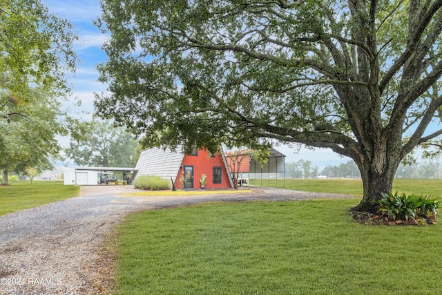 135 Woodys Ln, Sunset, LA 70584 - view of green lawn featuring an outdoor structure, driveway, a carport, and a garage
