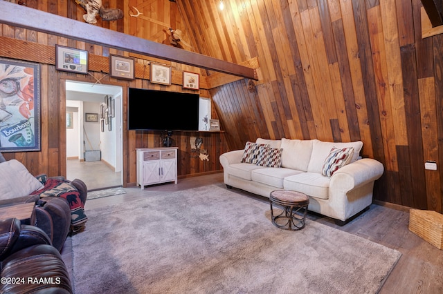 living room with hardwood / wood-style floors, wooden walls, and high vaulted ceiling