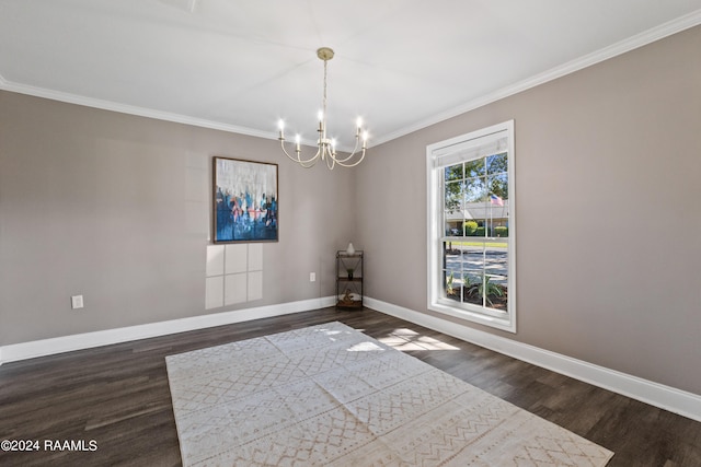 spare room with a notable chandelier, crown molding, and dark hardwood / wood-style flooring