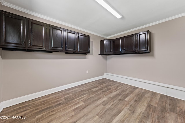 clothes washing area featuring crown molding and wood-type flooring